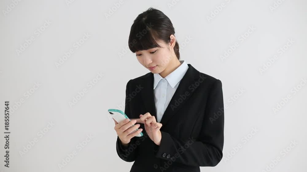 スーツで携帯電話を使う女性 スーツで携帯電話を使う女性
