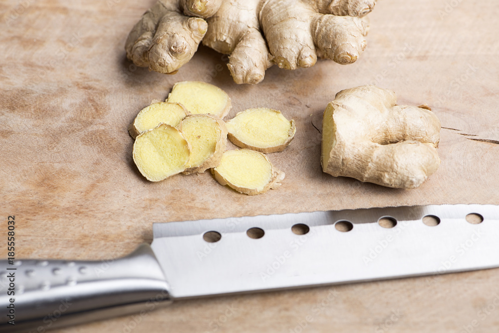 Fototapeta premium Ginger next to kitchen knife on wood. Food