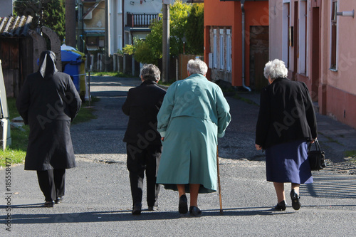 Four old ladies friends walking down the street