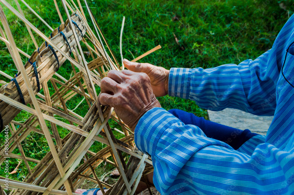 The basket-maker,Weave pattern hand bamboo, Bamboo weaving,Basket weaving , a village industry in thailand,Old Man's hands making a wicker basket