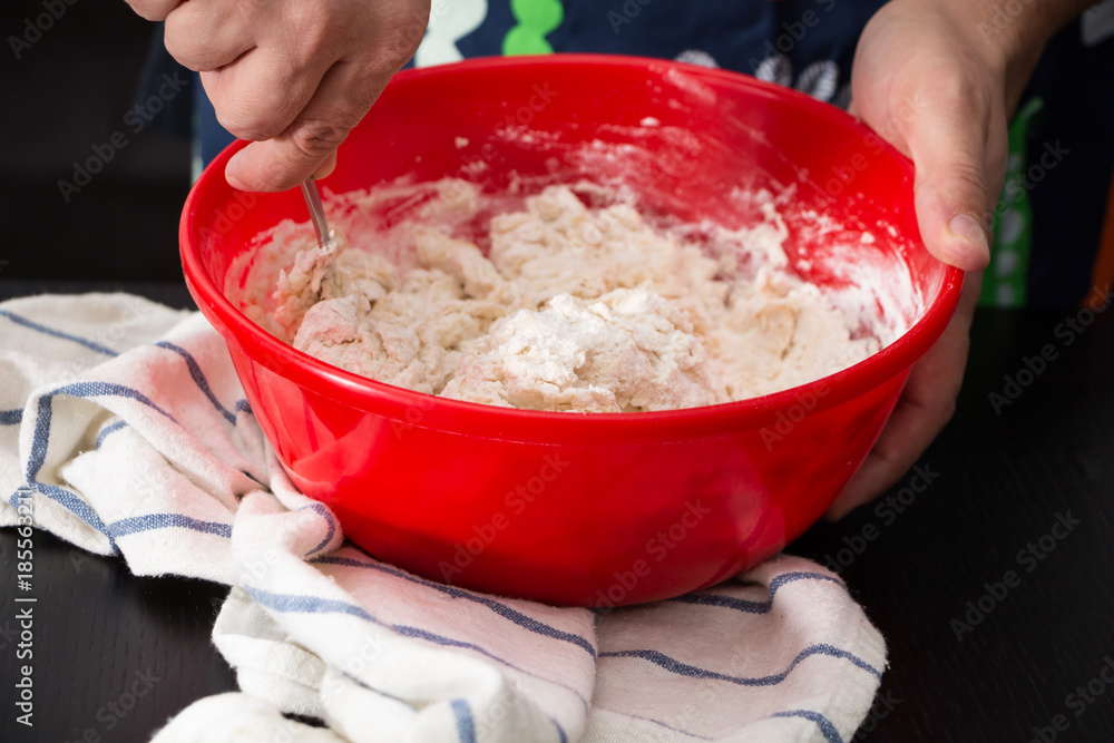 Male hands making/ mixing dough in red bowl, baking preparation closeup. Male hands making/ mixing dough in red bowl, baking preparation closeup.