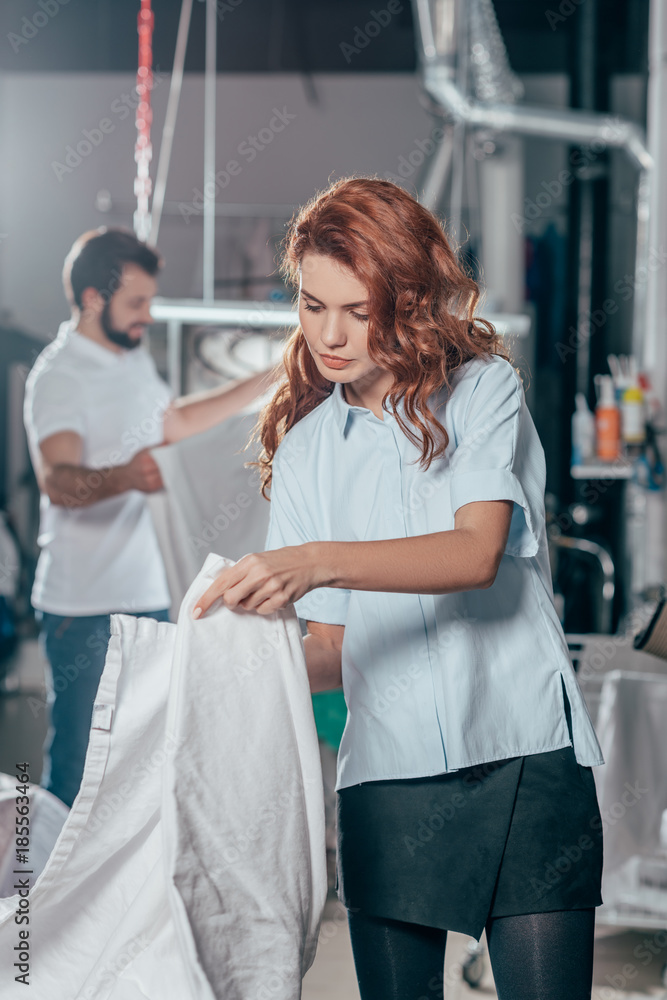 dry cleaning worker folding clean cloth at warehouse dry cleaning worker folding clean cloth at warehouse