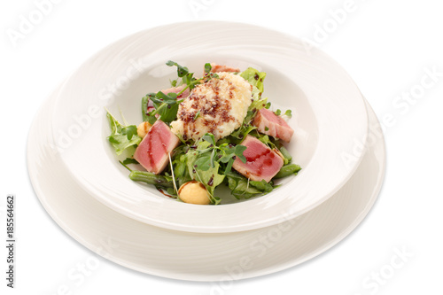 Salad of tuna, greens and green beans on a white plate