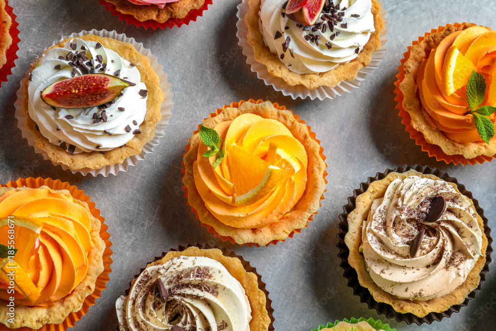 Tasty colorful cakes on grey background, top view Tasty colorful cakes on grey background, top view