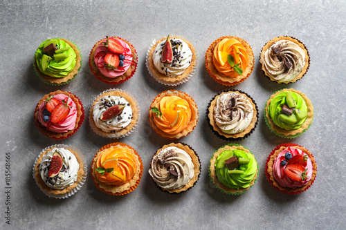 Fotografiet Tasty colorful cakes on grey background, top view