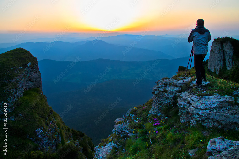 Photographer taking pictures of a beautiful sunshine in Ceahlau mountains
