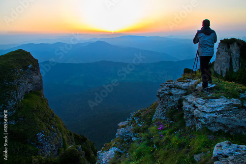 Photographer taking pictures of a beautiful sunshine in Ceahlau mountains