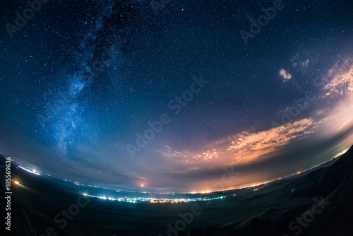 Night sky and milky way over a bright city