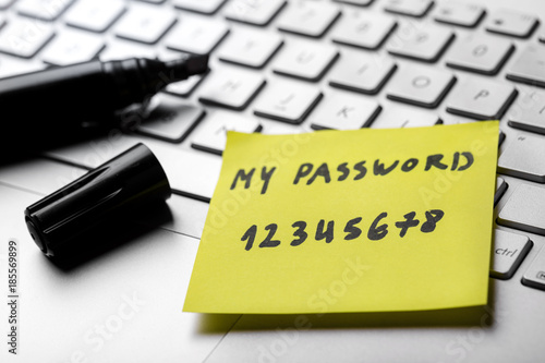 sticky note with weak easy password on laptop keyboard photo