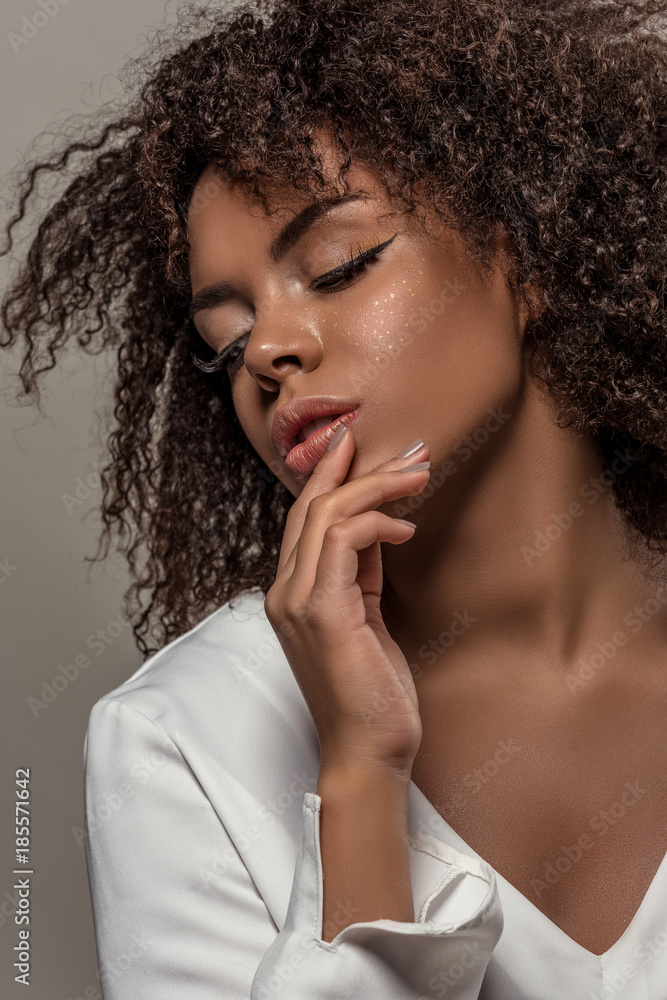Young sensual african american woman in white shirt isolated on grey background Young sensual african american woman in white shirt isolated on grey background