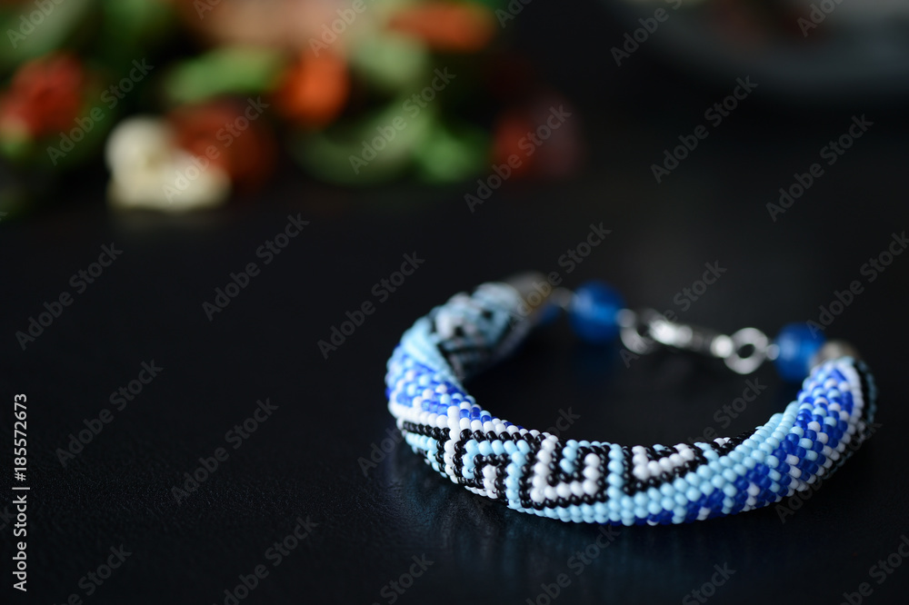 Blue beaded bracelet with greek ornament on a dark background close up Blue beaded bracelet with greek ornament on a dark background close up