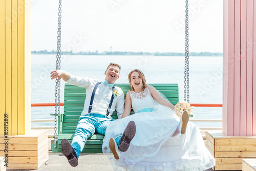 the bride and groom ride on a swing
