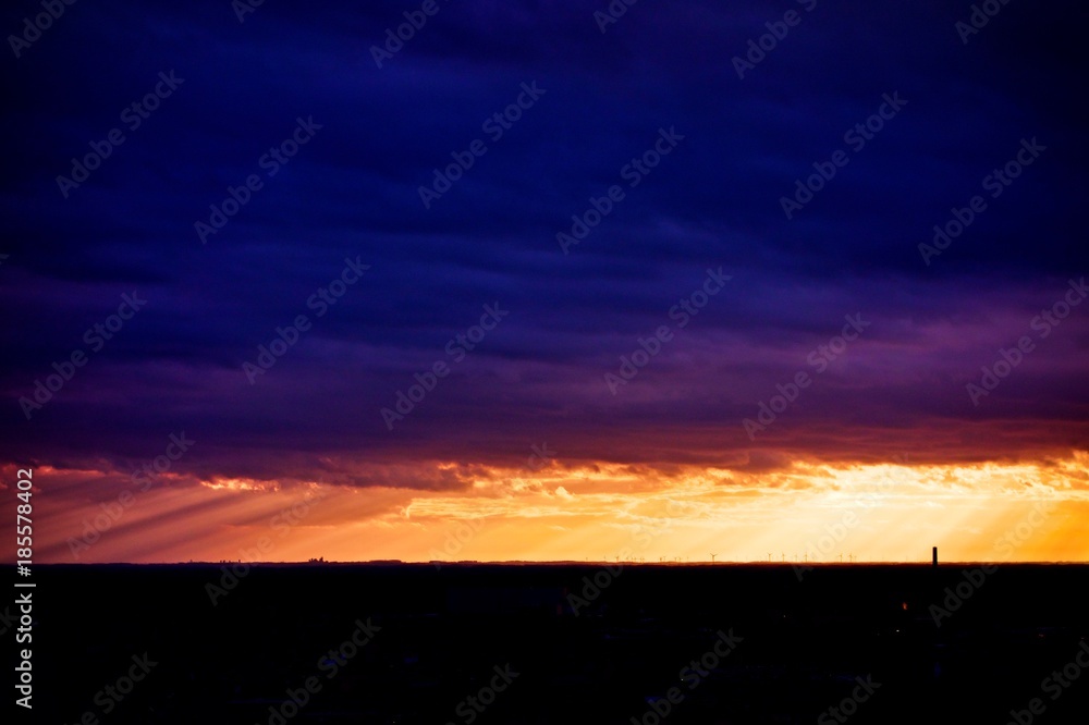 Picturesque dramatic panorama of sunset sky over dark flat skyline