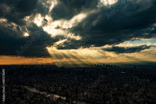 点から降り注ぐ光芒と東京の都心の風景