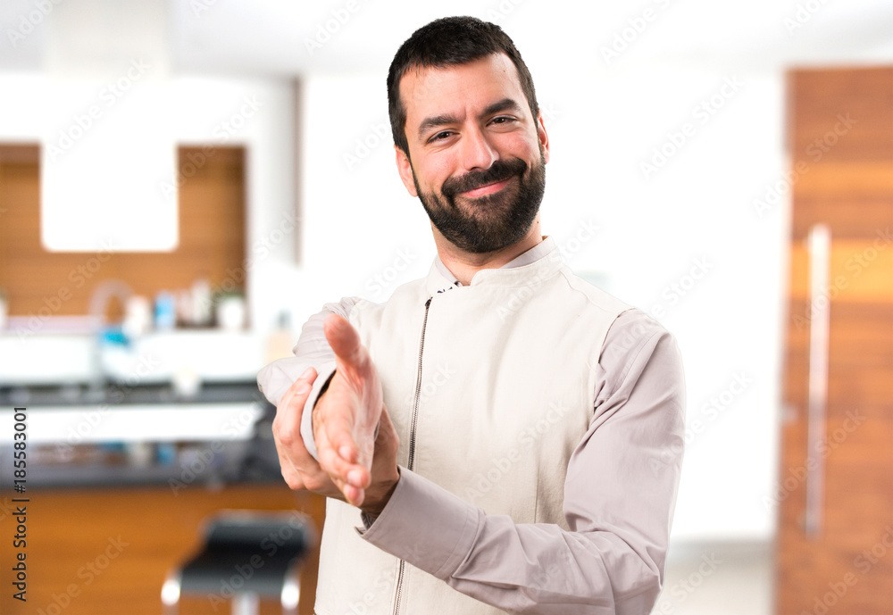 Handsome man with vest making a deal inside house Handsome man with vest making a deal inside house