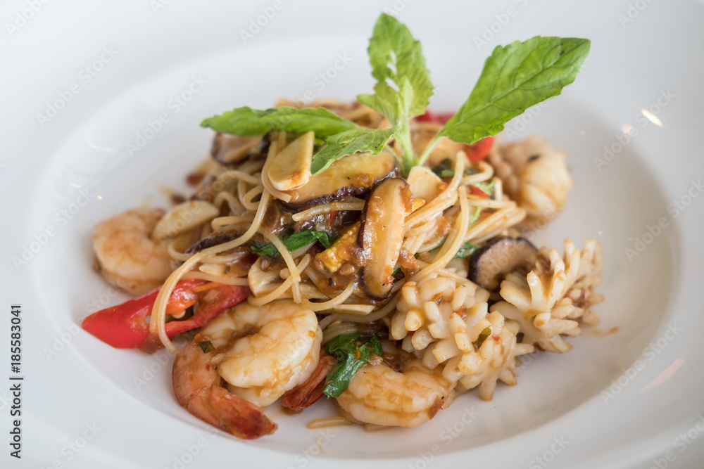 Spicy seafood spaghetti served on white plate Spicy seafood spaghetti served on white plate