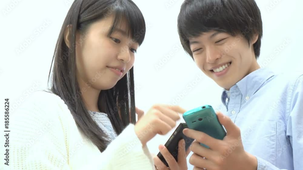 スマホ カップル男女 幸せ スマホを見ながら談笑 スマホ カップル男女 幸せ スマホを見ながら談笑