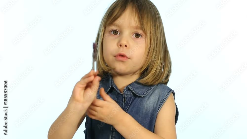 A child, a little girl in a denim dress, sits at a table and paints New Year's and Christmas cards. A child, a little girl in a denim dress, sits at a table and paints New Year's and Christmas cards.