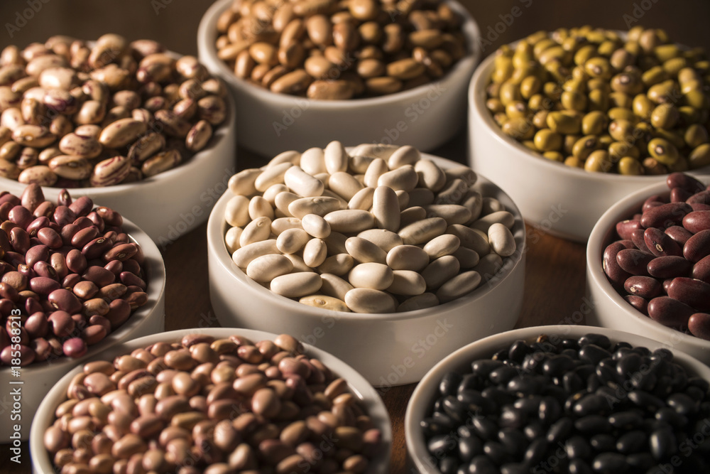 Assorted beans in bowls on wood background Assorted beans in bowls on wood background