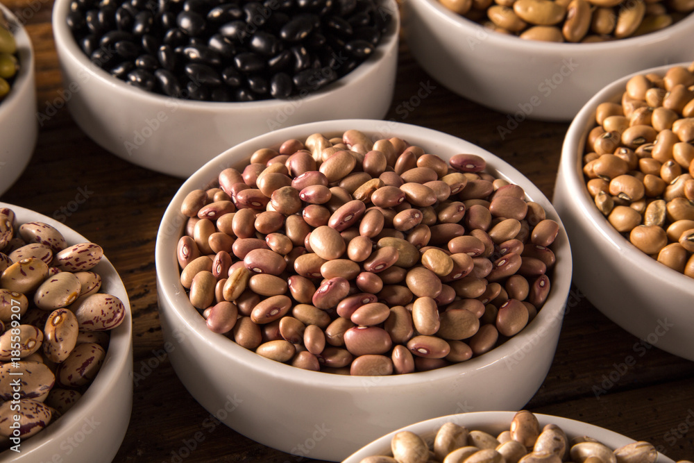 Assorted beans in bowls on wood background Assorted beans in bowls on wood background