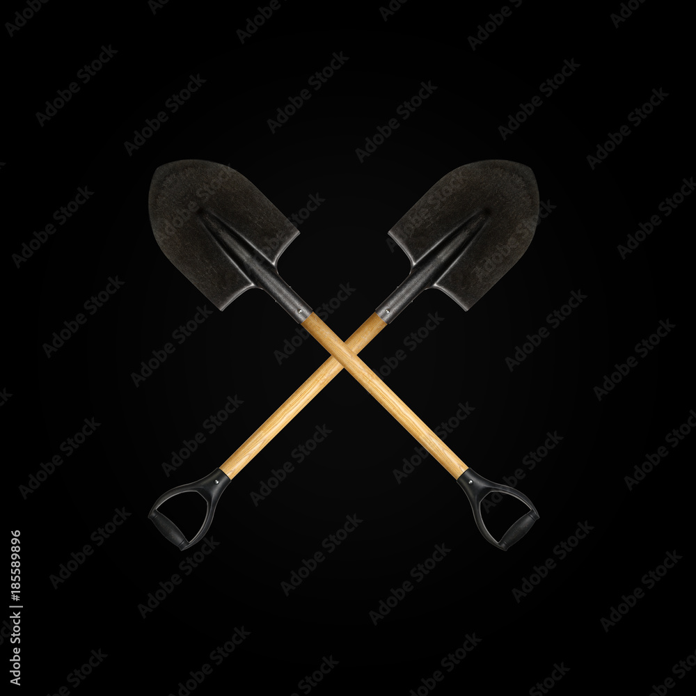 Two crossed shovel black background