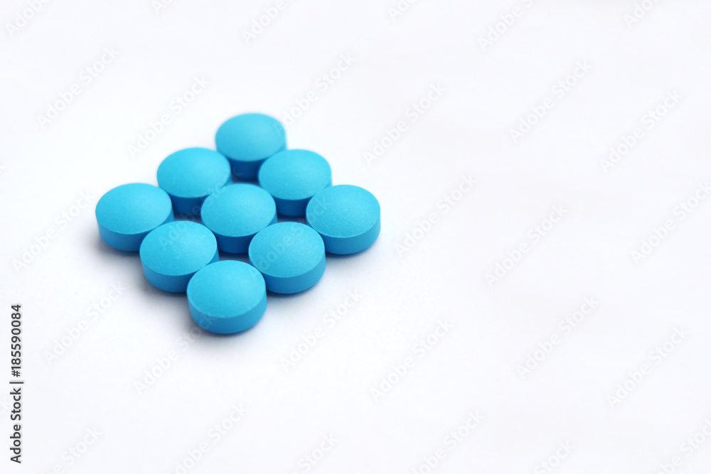 heap of blue tablets on white background copy space