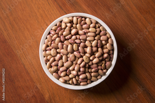 beans into a bowl on wooden background
