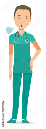 A male doctor wearing a green scrub is sighing