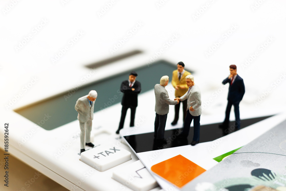 Miniature people, Businessmen handshake on calculator. Business Concept. Miniature people, Businessmen handshake on calculator. Business Concept.