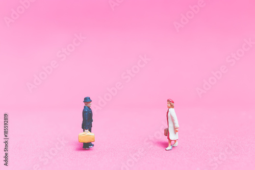 Miniature people   Couple of travellers on pink background    Valentine s day concept