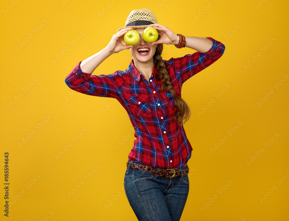 woman farmer holding apples in the front of face like big eyes woman farmer holding apples in the front of face like big eyes