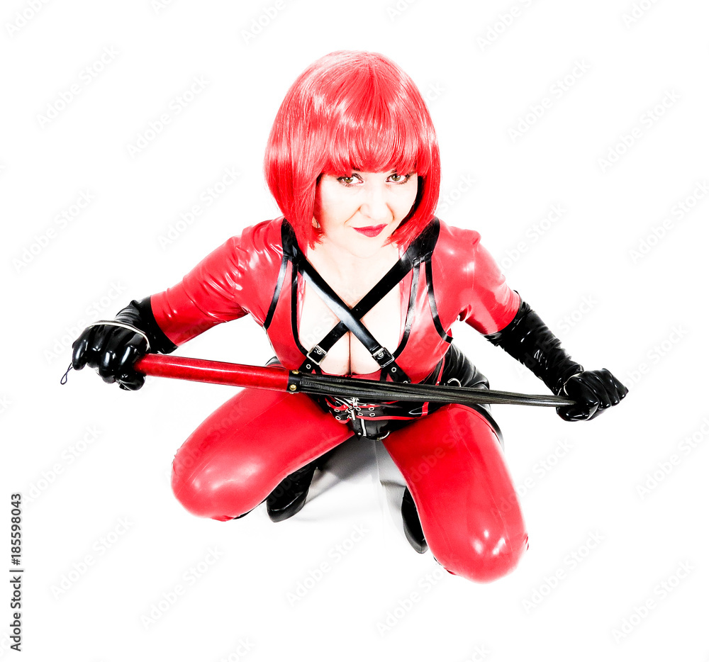 Fetish cosplay woman sitting on haunches in red catsuit. Fetish cosplay woman sitting on haunches in red catsuit.