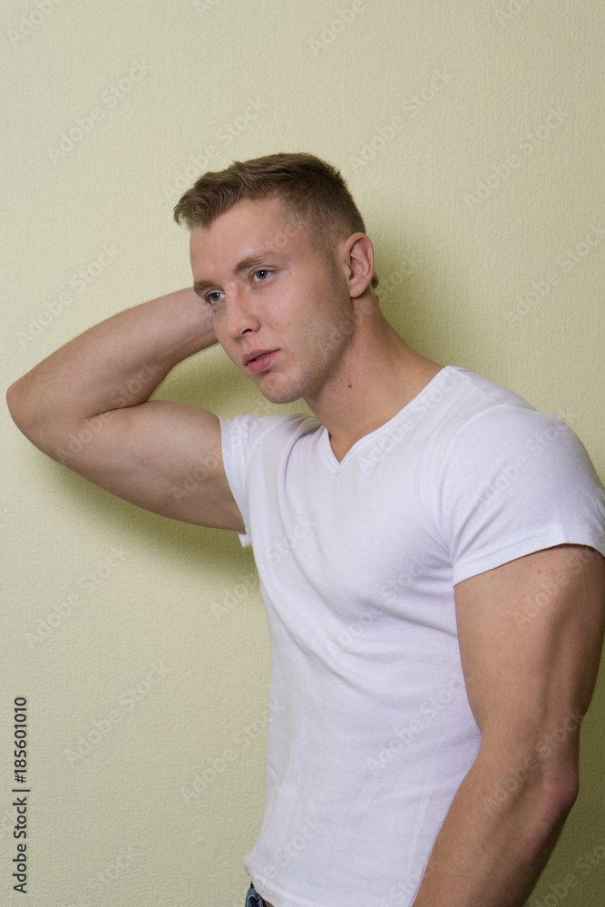 Young man , blue jeans and t-shirt, standing with hands in pockets - serious concept Young man , blue jeans and t-shirt, standing with hands in pockets - serious concept