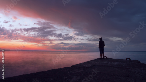people on the seawall follows the sunset / silhouette of a human landscape of Crimea nature