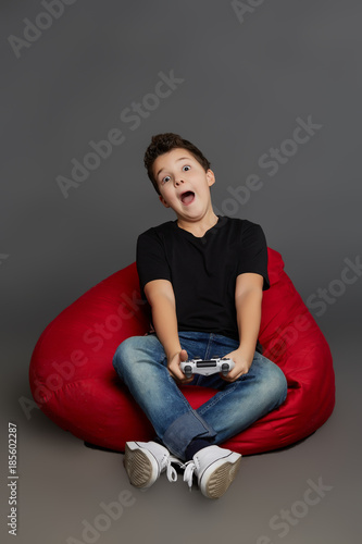 A cute boy in a black T-shirt and a white joystick