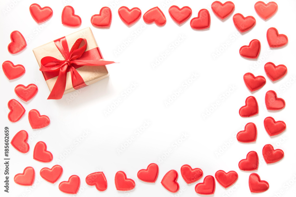 Red hearts and gift with red ribbon on white. Top view. Valentine's card concept. Red hearts and gift with red ribbon on white. Top view. Valentine's card concept.