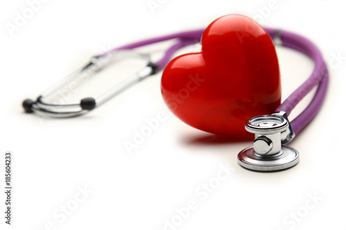 Heart with a medical stethoscope, isolated on wooden background