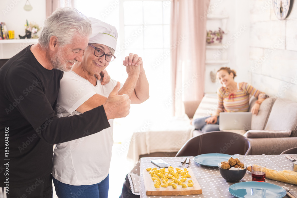 old woman makes homemade pasta and the happy family praises her skill. dough work for a successful result. Happy family of three people. two generations. old woman makes homemade pasta and the happy family praises her skill. dough work for a successful result. Happy family of three people. two generations.