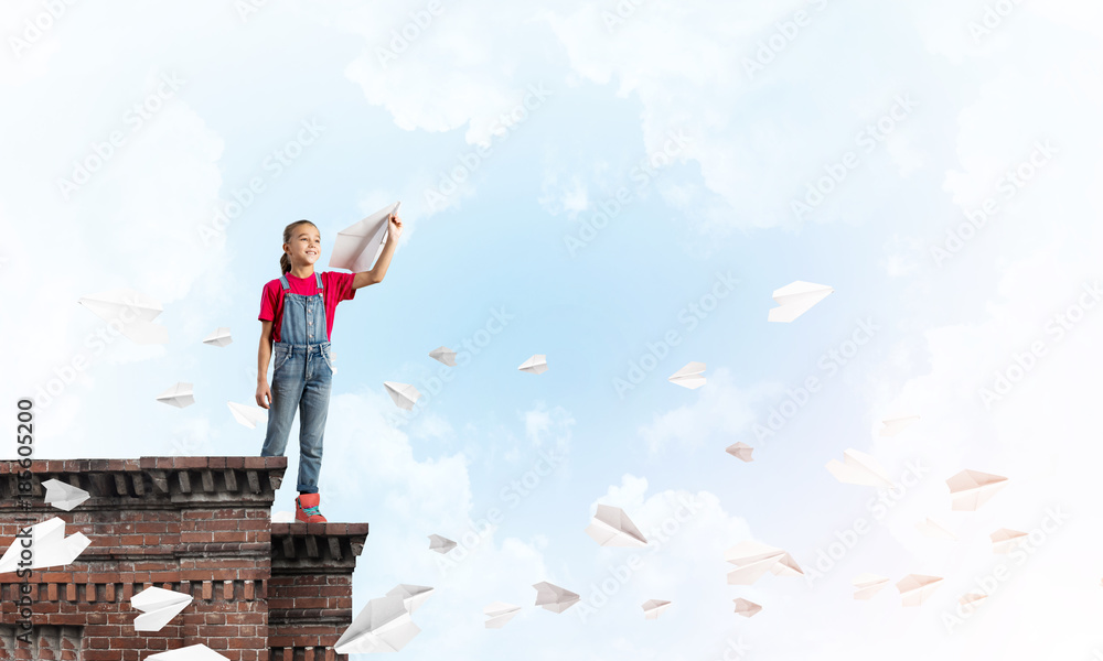 Concept of careless happy childhood with girl dreaming to become pilot