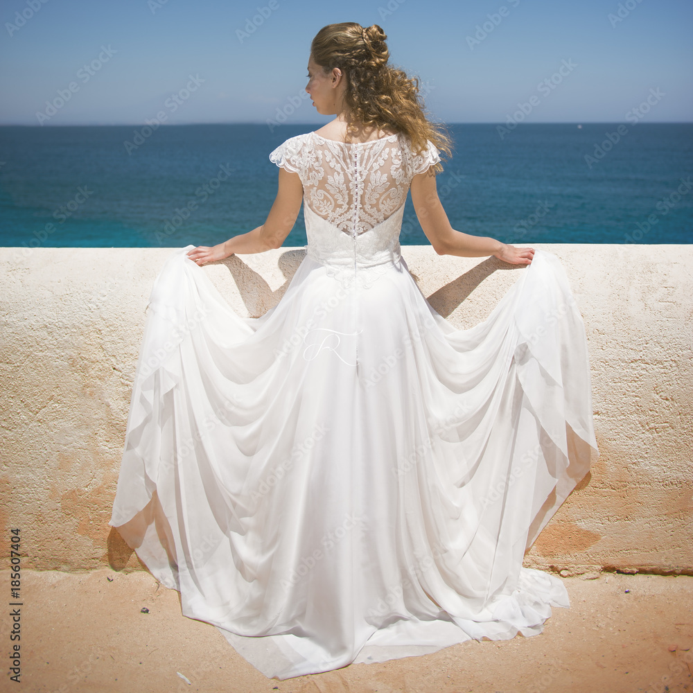 Beautiful girl seen from behind in a rural location at sea. Beautiful girl seen from behind in a rural location at sea.