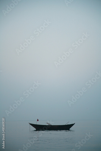 An empty old fishing boat in the calm water of the sea