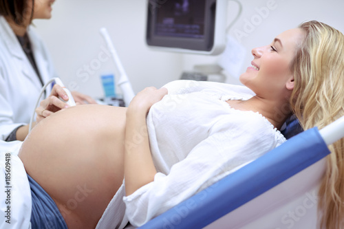 Cheerful pregnant woman on ultrasound photo