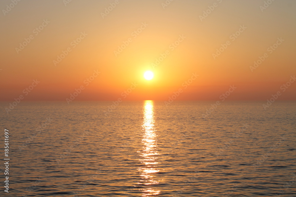 Obraz premium sunset on ocean red orange sinking sun in sea