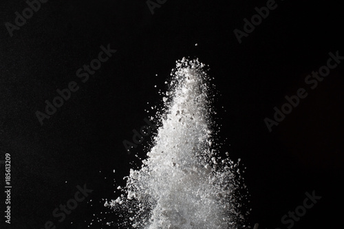 Fototapeta Naklejka Na Ścianę i Meble -  White powder. Grainy abstract texture on black background.