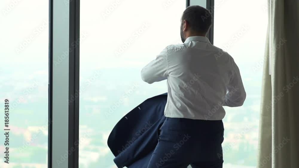 Elegant man putting on jacket by window at home, super slow motion 240fps
Elegant man putting on jacket by window at home, super slow motion 240fps