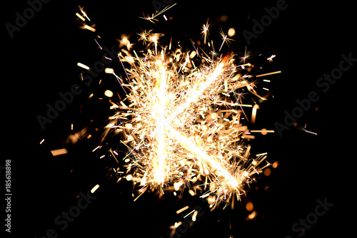 Letter "K" made of sparklers isolated background.