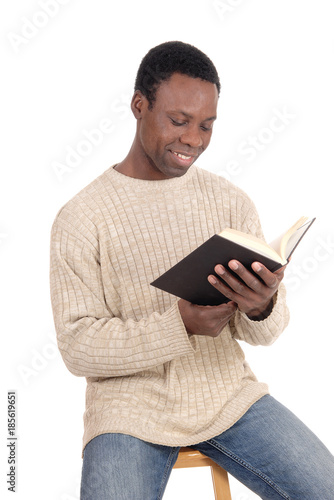 African man sitting and reading his book