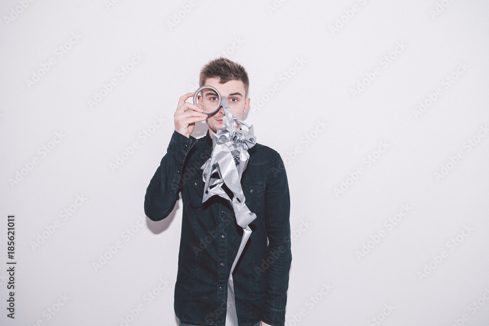 boy looks through a coil of spoiled grey scotch tape boy looks through a coil of spoiled grey scotch tape