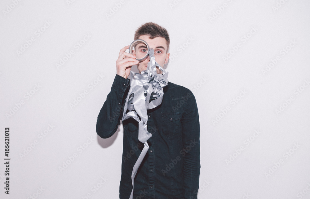 boy looks through a coil of spoiled grey scotch tape boy looks through a coil of spoiled grey scotch tape