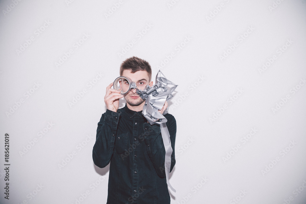 boy looks through a coil of spoiled grey scotch tape boy looks through a coil of spoiled grey scotch tape